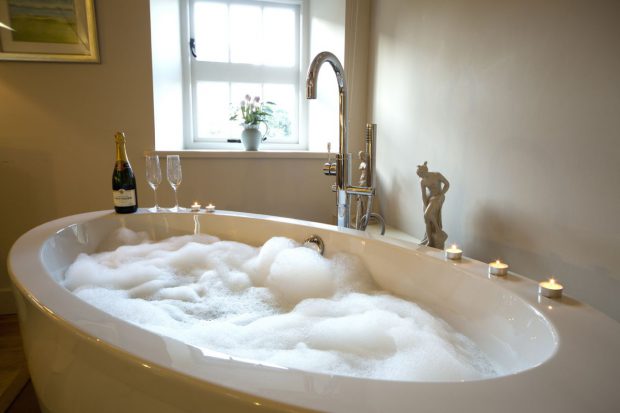 cottage with freestanding bath at foot of bed